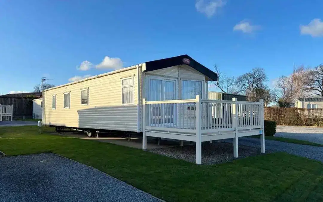 Carnaby Cascade static caravan with modern cladding, large front windows, and deck in a holiday park