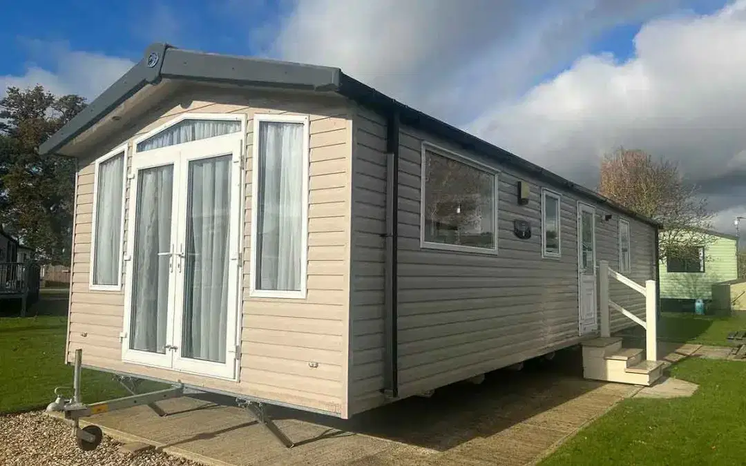 Swift Biarritz static caravan with modern white cladding and large front windows in a holiday park