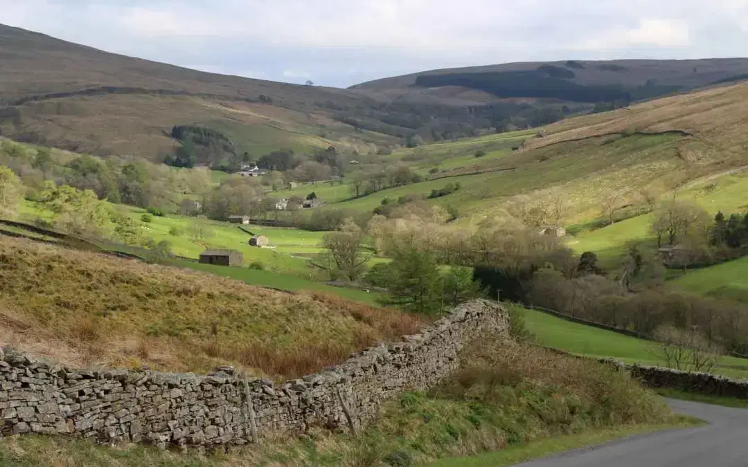 Rolling green hills and stone walls in a peaceful countryside valley